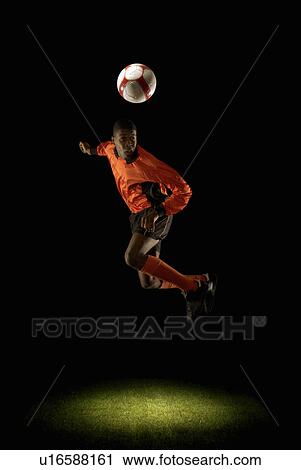Footballer mid air heading ball View Large Photo Image Stock Image - Footballer mid air heading ball. Fotosearch