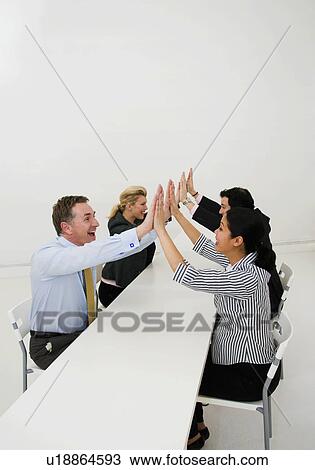 Stock Image - Four colleagues celebrate. Fotosearch