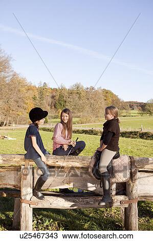Stock Image - Friends at a stable. Fotosearch