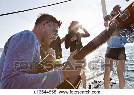 Friends dancing with guitar on yacht View Large Photo Image Stock Photo - Friends dancing with guitar on yacht. Fotosearch