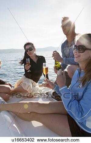 Stock Image - Friends with champagne on yacht. Fotosearch
