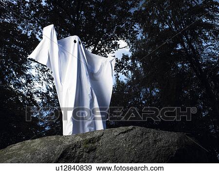 Stock Photo - Ghost made of sheets, standing on a rock. Fotosearch