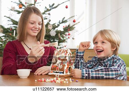 Stock Photo - girl, boy decorating gingerbread house. Fotosearch