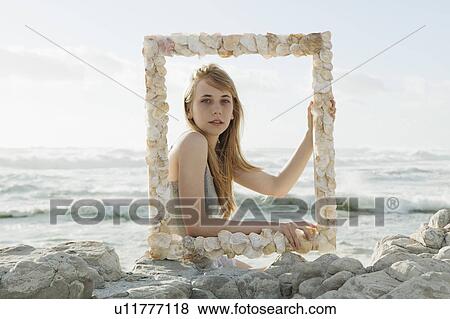 Girl holding shell picture frame View Large Photo Image Stock Photo - Girl holding shell picture frame. Fotosearch