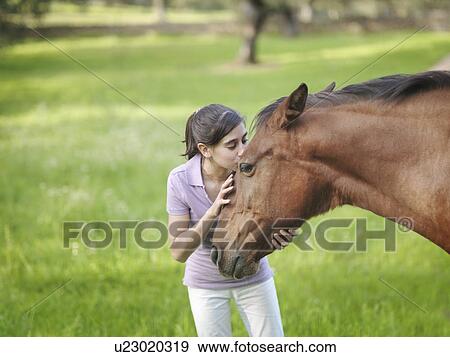Stock Photo - Girl kissing horse on forehead. Fotosearch