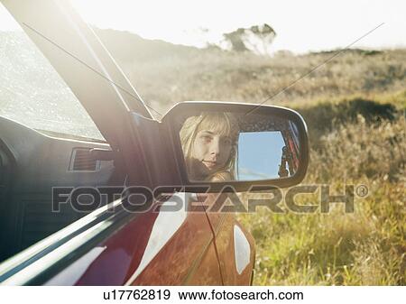 Stock Photo - Girl looking in car mirror. Fotosearch