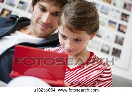 Girl playing video game dad watching View Large Photo Image Picture - Girl playing video game dad watching. Fotosearch