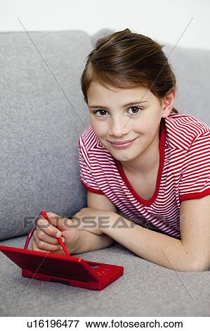Girl playing video game on couch View Large Photo Image Stock Photo - Girl playing video game on couch. Fotosearch