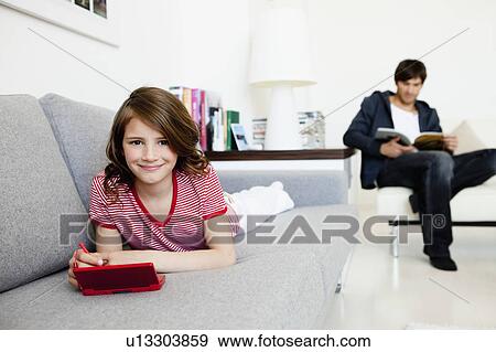 Girl playing video games father reading View Large Photo Image Stock Photo - Girl playing video games father reading. Fotosearch