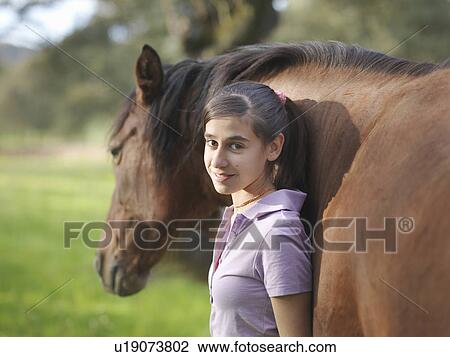 Stock Image - Girl posing with her horse. Fotosearch