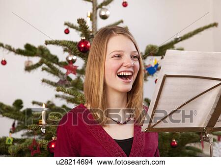 Picture - girl singing christmas carols. Fotosearch