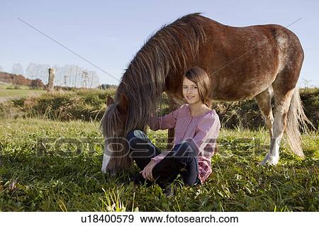 Girl sitting beside horse View Large Photo Image Stock Photo - Girl sitting beside horse. Fotosearch