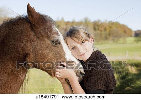 Girl stroking a horse View Large Photo Image Stock Image - Girl stroking a horse. Fotosearch