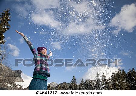 Girl throwing snow into the air View Large Photo Image Stock Image - Girl throwing snow into the air. Fotosearch