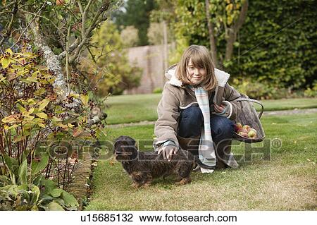 Girl with basket and dog in garden View Large Photo Image Stock Image - Girl with basket and dog in garden. Fotosearch