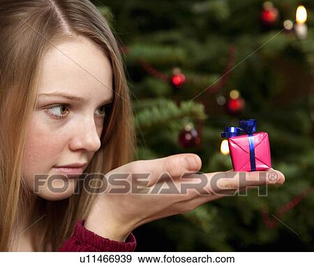 Stock Photo - girl with small christmas present. Fotosearch