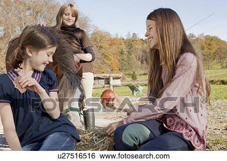 Stock Photograph - Girls with horse. Fotosearch