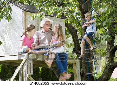 Stock Image - Grandfather reading a book. Fotosearch