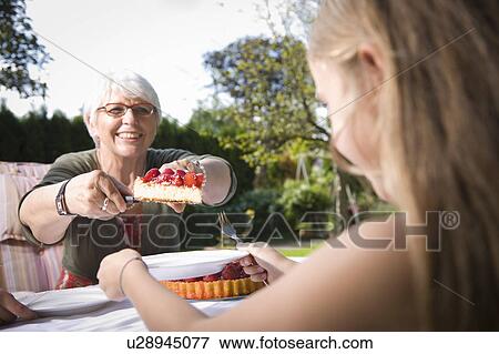 Stock Photo - Grandmother handing pie. Fotosearch