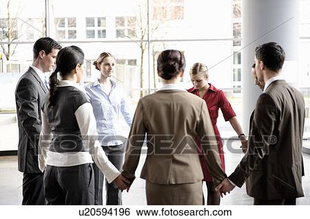 Stock Photograph - Group of business people forming circle. Fotosearch