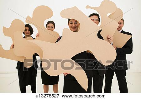 Group of business people hold jigsaw View Large Photo Image Stock Photo - Group of business people hold jigsaw. Fotosearch