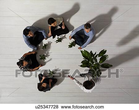 Stock Photo - Group of people on floor with plants. Fotosearch