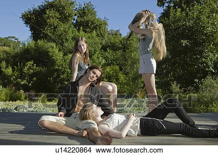 Picture - Group of young adults lying in sun. Fotosearch