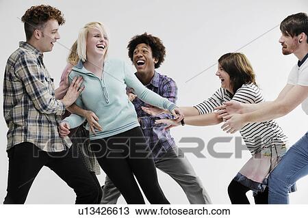 Stock Image - Group of young adults pushing each other. Fotosearch