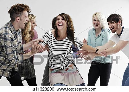 Group of young adults pushing each other View Large Photo Image Stock Photograph - Group of young adults pushing each other. Fotosearch