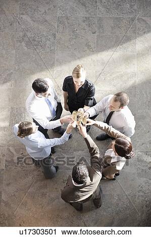 Stock Image - Happy business executives with champagne. Fotosearch