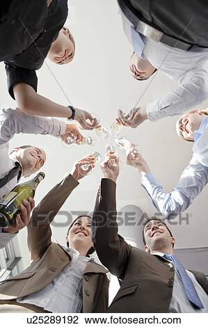 Stock Image - Happy business executives with champagne. Fotosearch