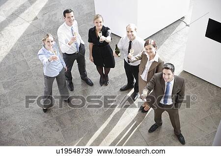 Stock Photo - Happy business executives with champagne. Fotosearch
