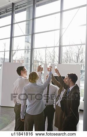 Stock Photograph - Happy business executives with champagne. Fotosearch