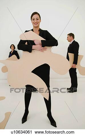 Stock Image - Happy Women holds large jigsaw piece. Fotosearch