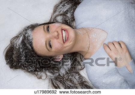 Happy young woman lays in snow View Large Photo Image Stock Image - Happy young woman lays in snow. Fotosearch