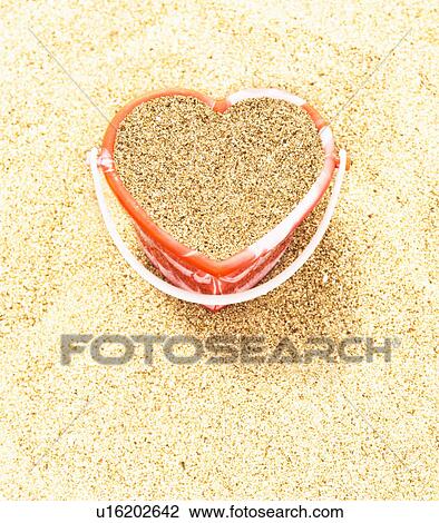 Stock Image - Heart shaped bucket of sand. Fotosearch