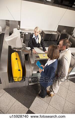 Stock Image - Lady checking the weight of a suitcase. Fotosearch