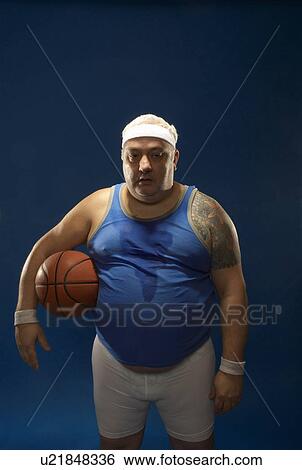Stock Photograph - Large sportsman holding basketball. Fotosearch