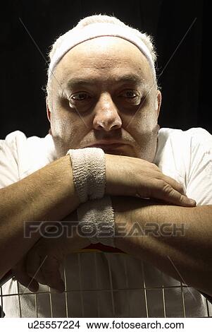 Picture - Large tennis player resting on racquet. Fotosearch
