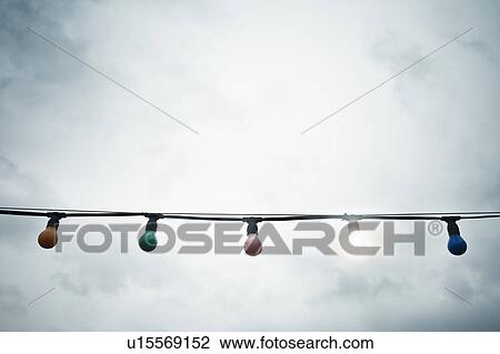 Stock Image - Light bulbs against sky. Fotosearch