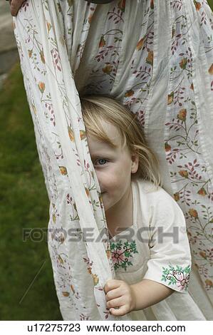 Little girl hiding behind curtains View Large Photo Image Stock Image - Little girl hiding behind curtains. Fotosearch