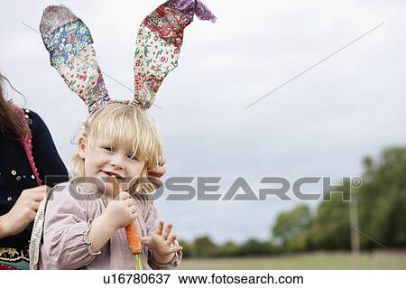 Little girl nibbling with bunny ears View Large Photo Image Stock Photo - Little girl nibbling with bunny ears. Fotosearch