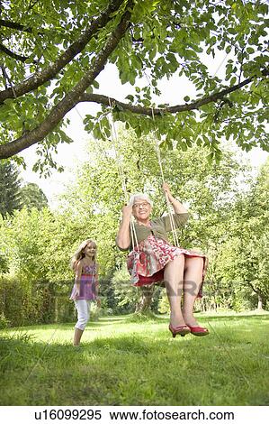 Stock Photography - Little girl pushing her grandmother. Fotosearch