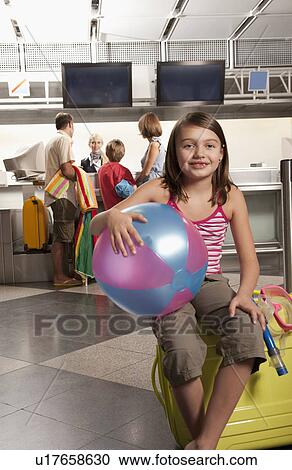 Little girl sitting on a suitcase View Large Photo Image Stock Image - Little girl sitting on a suitcase. Fotosearch