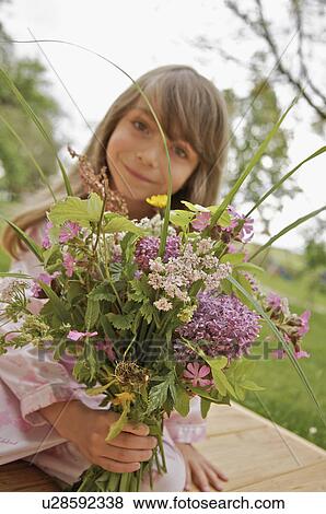 Little girl with a bouquet of flowers View Large Photo Image Stock Photo - Little girl with a bouquet of flowers. Fotosearch