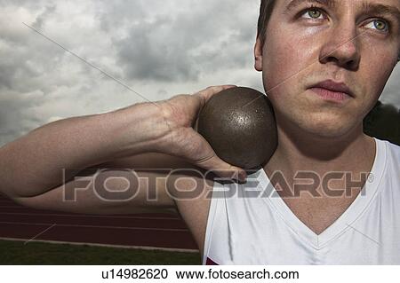 Stock Image - male athlete putting shot. Fotosearch