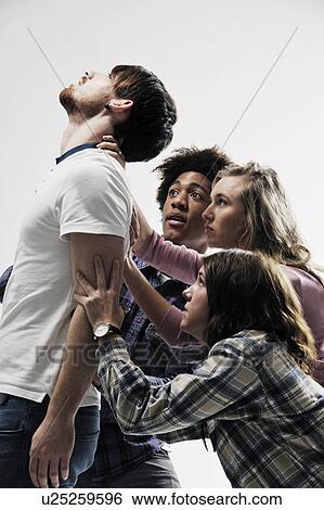 Male being supported by 3 people View Large Photo Image Stock Photograph - Male being supported by 3 people. Fotosearch