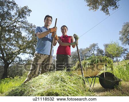 Man and woman in front of hay heap View Large Photo Image Stock Image - Man and woman in front of hay heap. Fotosearch