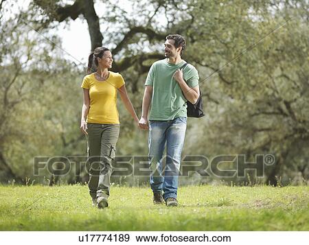 Man and woman walking hand in hand View Large Photo Image Stock Photo - Man and woman walking hand in hand. Fotosearch