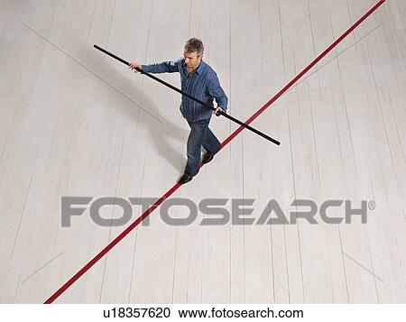 Man balancing on thin red line with pole View Large Photo Image Stock Image - Man balancing on thin red line with pole. Fotosearch
